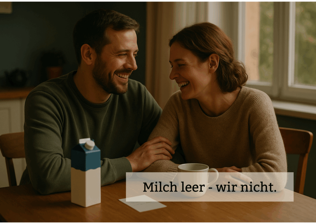Ein lachendes Paar sitzt am Frühstückstisch, eine leere Milchpackung steht davor – Symbol für Humor, Liebe und Zusammenhalt.