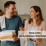 Paar lacht gemeinsam beim Wäschefalten in der Küche – Teamarbeit im Alltag und Haushalt